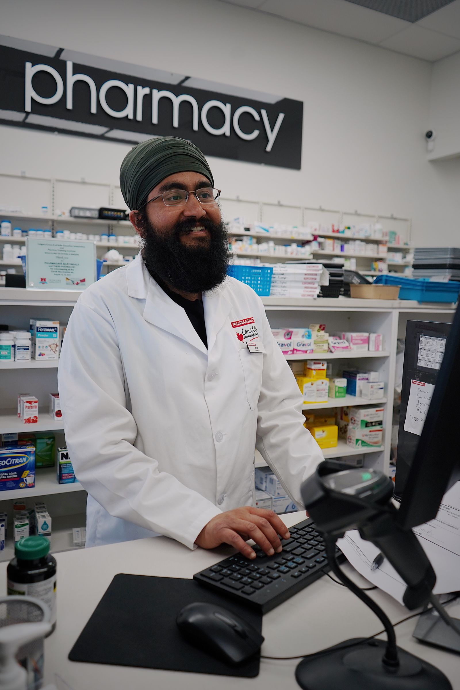 A smiling pharmacist working at the pharmacy counter